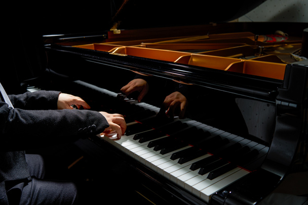Een pianist speelt op de vleugel - Foto, afbeelding