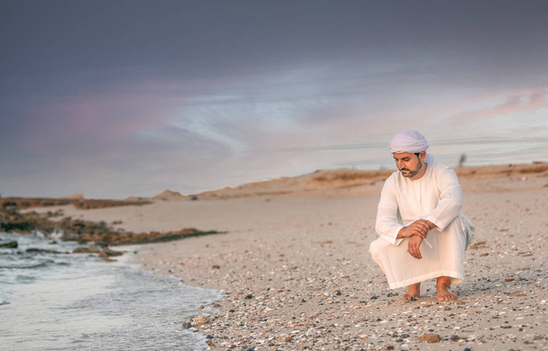 jóképű fiatal arab férfi a tengerparton az Egyesült Arab Emírségekben - Fotó, kép