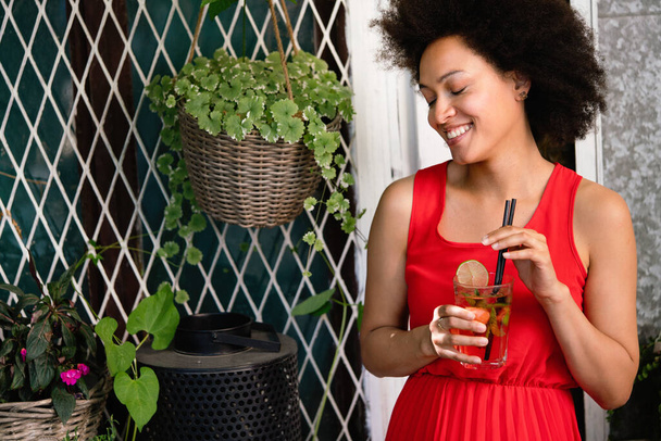 Lifestyle fashion portrait of black woman posing on the street with drink - Φωτογραφία, εικόνα