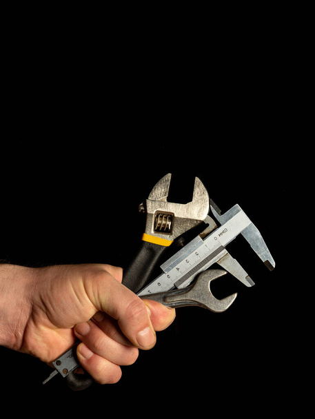 La main du maître tient un ensemble d'outils pour réparer la plomberie - Photo, image