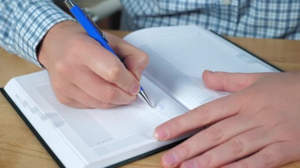 Primer plano manos de hombre de negocios escribe lista de tareas pendientes en los trabajos de cuaderno en la oficina en casa - Metraje, vídeo