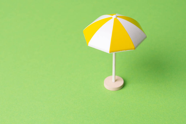 разноцветный пляжный зонтик на желтом фоне - Фото, изображение