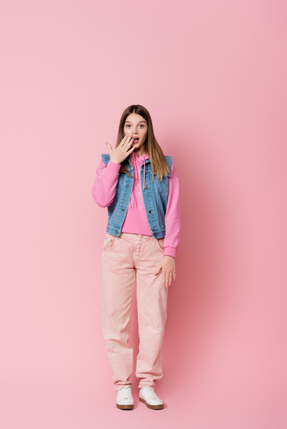 Amazed teenager looking at camera on pink background - Foto, Bild