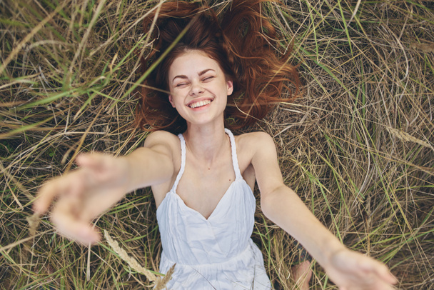 happy woman in haystack stretches hands up and cropped view - Foto, Imagen