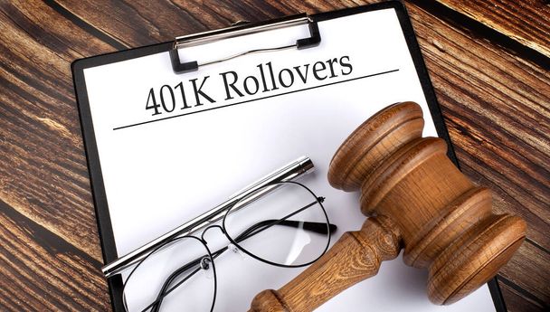 Paper with 401k Rollovers with gavel, pen and glasses on wooden background - Photo, Image