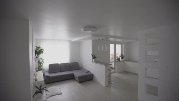 Eetkamer en woonkamer van nieuw huis. Grote grijze bank in vakantiehuis of vakantievilla. appartement na renovatie - Video