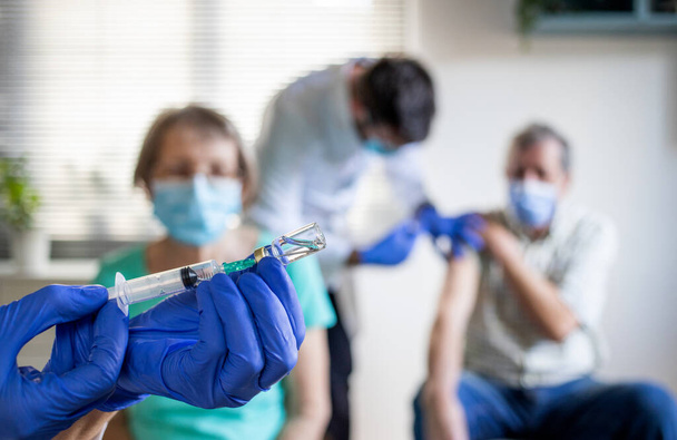 ιατρική ομάδα που χορηγεί το εμβόλιο του κορωναϊού σε ηλικιωμένους - Φωτογραφία, εικόνα