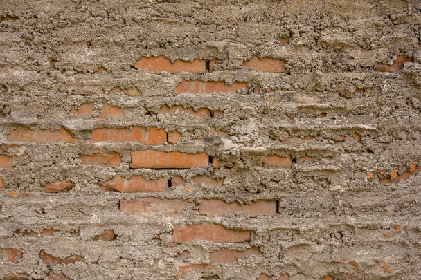 rode bakstenen muur met slordig cement. ruwe oppervlaktestructuur - Foto, afbeelding