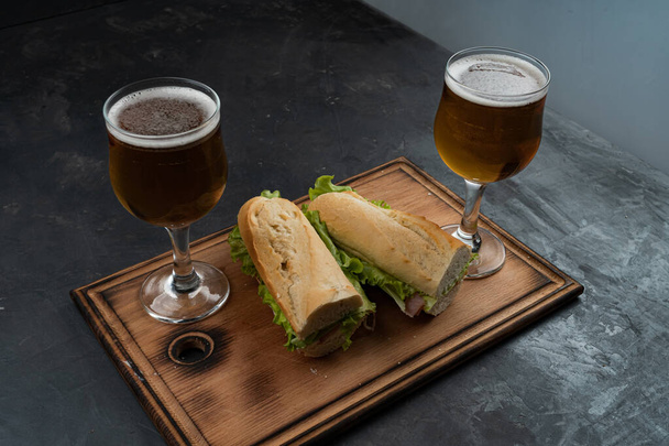 Sandwiches and beer on a wooden table - Photo, Image