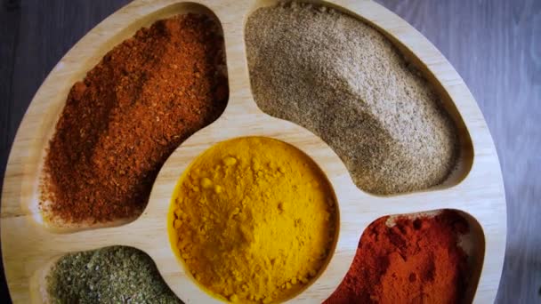 Spices footage.Various Indian Spices on wood table.spice turned on wood table.turmeric, red pepper, pepper, chilli and oregano - Кадри, відео