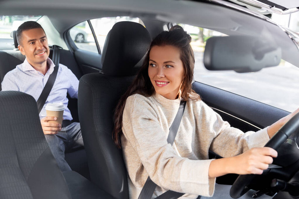 female driver driving car with male passenger - Foto, Imagem