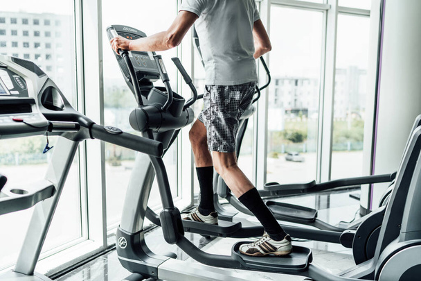 The photo shows a man performing cardio, a modern gym, health and sports. - Photo, image