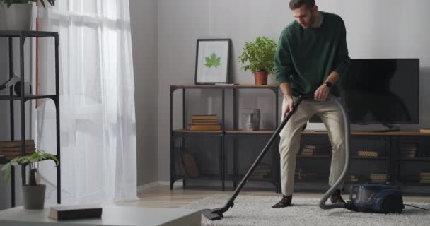 cleaning carpet with vacuum cleaner, husband is dancing and hoovering, helping about house, having fun - Footage, Video