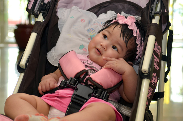 Mignon asiatique bébé fille souriant tout en étant assis dans sa poussette
 - Photo, image
