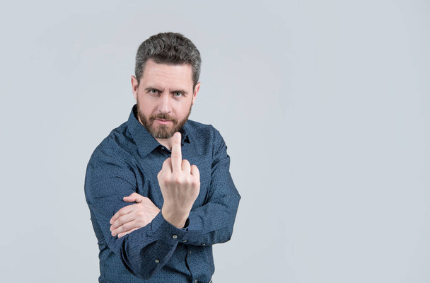 Flipping someone off. Bearded man show middle finger upwards. Obscene hand gesture. Finger. Symbol of contempt. Intentional disrespect. Intimidation and threatening, copy space. - Photo, Image