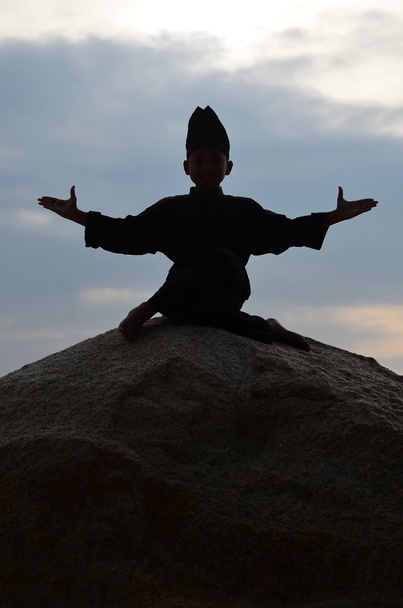 Silhouette of young boy performing a pencak silat, Malay traditional discipline martial art - Photo, Image