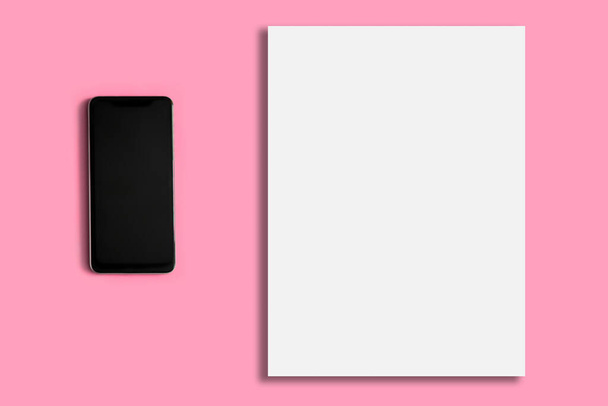 White blank sheet on a pink background. Telephone. - Fotó, kép