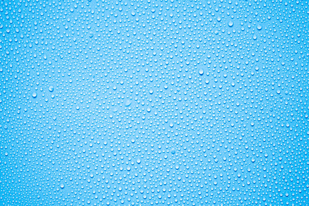 αφηρημένες σταγόνες νερού στο τζάμι του παραθύρου με μπλε φόντο  - Φωτογραφία, εικόνα