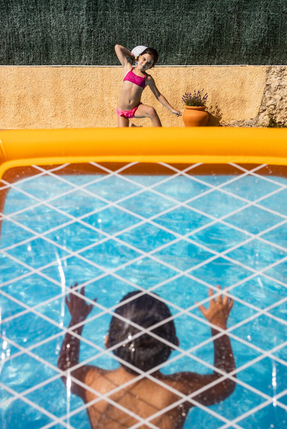 Dwoje dzieci bawiących się piłką na basenie - Zdjęcie, obraz