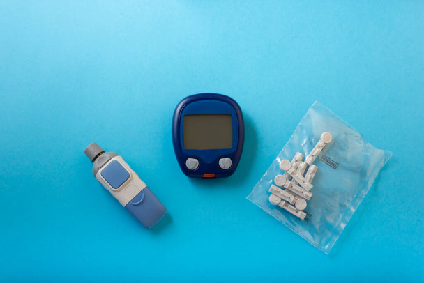 medicína, cukrovka, glykémie, zdravotní péče a koncept lidí - detailní kontrola hladiny cukru v krvi u člověka pomocí glukometru a testovacího pruhu doma - Fotografie, Obrázek