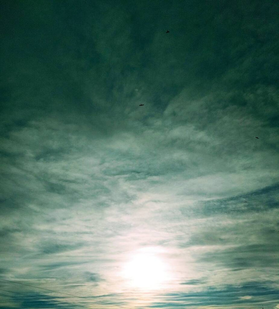 Aurinko paistaa pilvien läpi taivaalla, luonnollinen tausta  - Valokuva, kuva