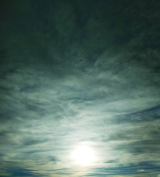 Güneş gökyüzündeki bulutların arasından ışıl ışıl parlıyor, doğal arka plan  - Fotoğraf, Görsel