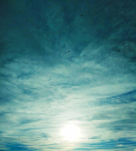 Güneş gökyüzündeki bulutların arasından ışıl ışıl parlıyor, doğal arka plan  - Fotoğraf, Görsel