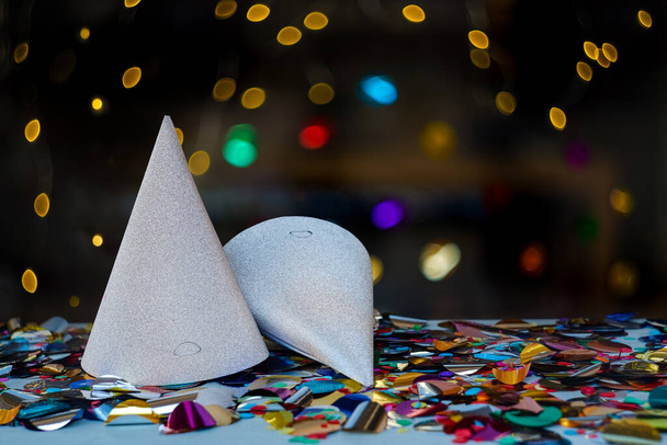 Fiesta nocturna con luces vibrantes, confeti colorido y hermosos sombreros de plata brillante - Foto, Imagen