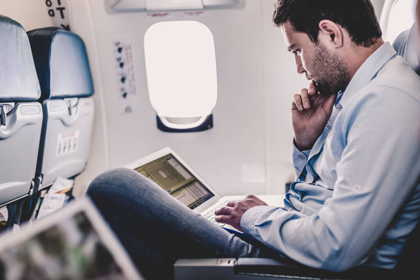 Homme d'affaires travaillant avec un ordinateur portable sur avion. - Photo, image