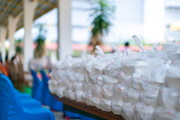 Pacotes asiáticos de alimentos de espuma são preparados em saco plástico para doação a pessoas. - Foto, Imagem