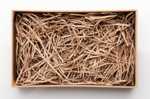 Üst görünümün üzerinde parçalanmış kağıt olan kahverengi kutuyu aç - Fotoğraf, Görsel