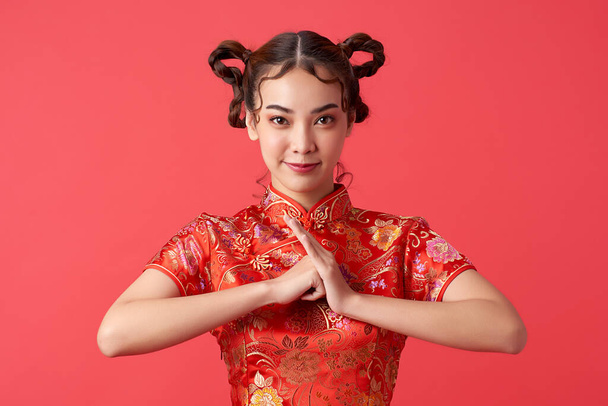 Ασιάτισσα Κινέζα με παραδοσιακό φόρεμα σε κόκκινο φόντο. Κινέζικο φεστιβάλ νέου έτους - Φωτογραφία, εικόνα