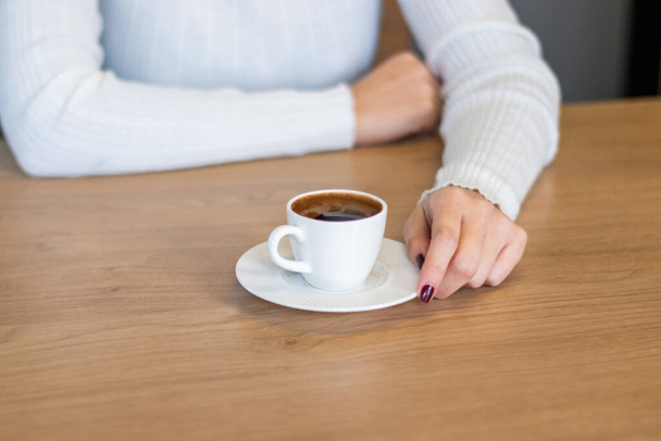 Nainen puupöydällä pitelemässä turkkilaista kahvia käsilläsi - Valokuva, kuva