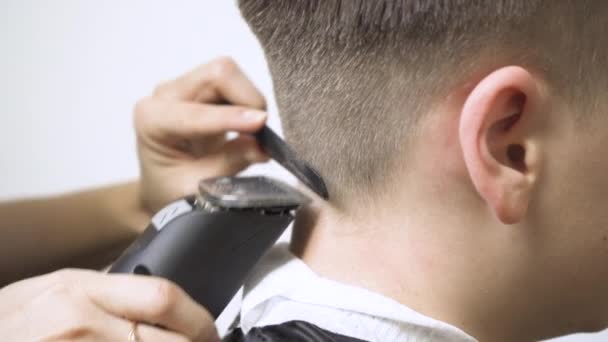 Acercamiento de la cortadora de cabello en la parte posterior de la cabeza con una cortadora de cabello. - Imágenes, Vídeo