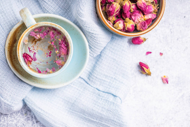 Cup of roses tea with rose buds on light background. Tea with rose. - Zdjęcie, obraz