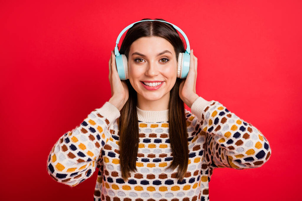 Photo portrait of cheerful girl wearing blue earphones wireless listening music isolated vibrant red color background - Zdjęcie, obraz
