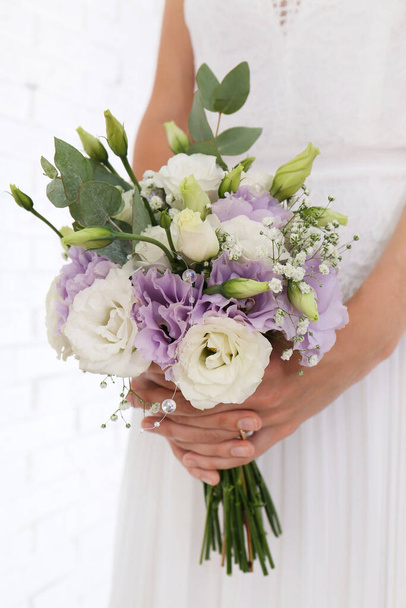 Bride holding beautiful bouquet with Eustoma flowers indoors, closeup - Foto, afbeelding
