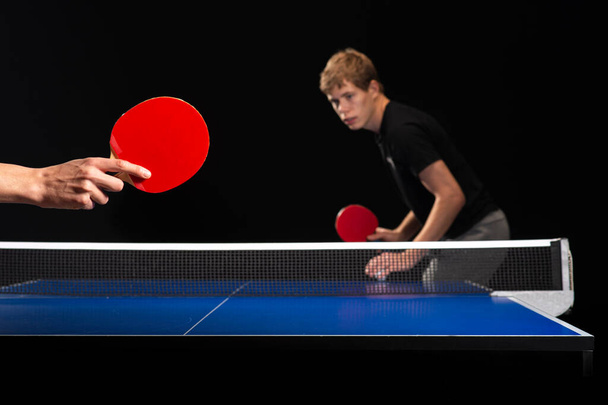 Zwei junge Jungen spielen Tischtennis, konzentrieren sich auf Schläger - Foto, Bild