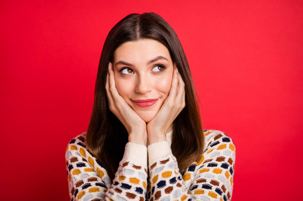 Portrait of optimistic nice girl look empty space hands face wear colorful sweater isolated on red color background - Zdjęcie, obraz