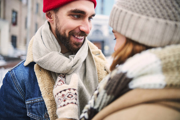 Jolly bearded guy dating with female outdoors in winter - Foto, Imagen