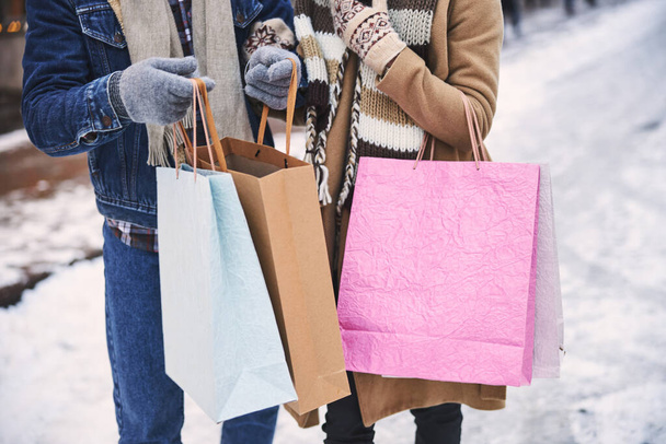 Loving couple buying presents at Christmas holidays outdoors - Фото, зображення