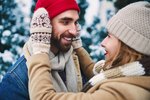 Smiling young couple spending time in snowy wood - 写真・画像