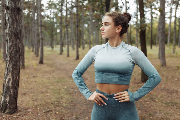 Portrait de femme de fitness séduisante en vêtements de sport à la forêt - Photo, image