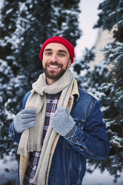 Веселий чоловік насолоджується сніжною погодою в парку
 - Фото, зображення