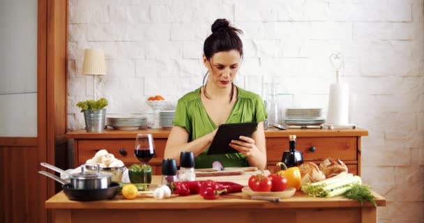 Hermosa mujer comprueba la receta de alimentos de primavera en la tableta - Metraje, vídeo