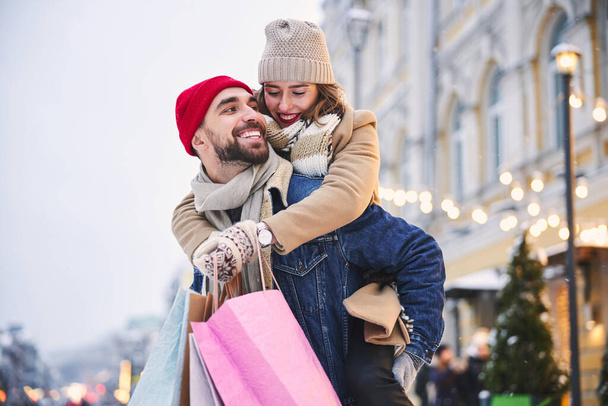 Happy young couple going shopping in winter - Foto, Imagen