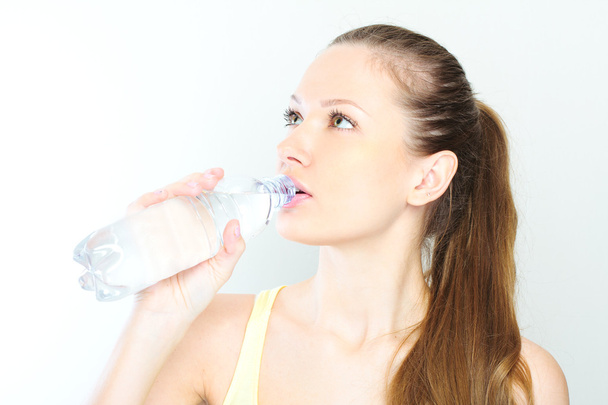 beautiful woman with bottle of water over white - Фото, изображение