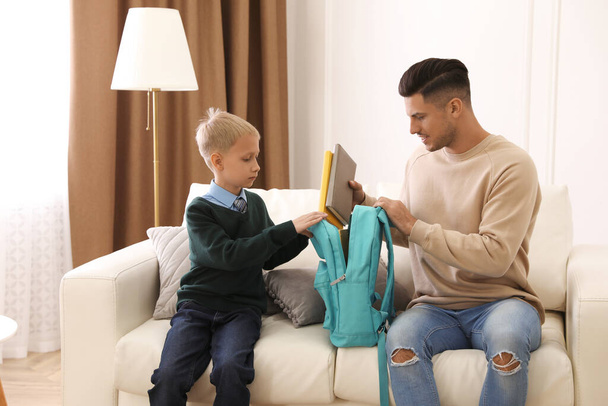 Father helping his little child get ready for school at home - Φωτογραφία, εικόνα