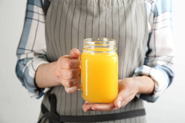 Woman holding mason jar of immunity boosting drink in hands, closeup - Фото, зображення
