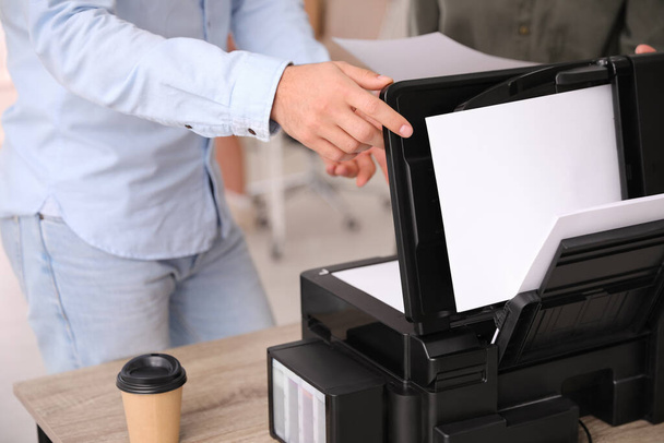 Employee using modern printer in office, closeup - Фото, изображение